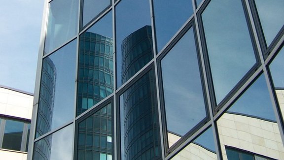 Produktbroschüre BauStatik - Glasbau Titel der Produktbroschüre BauStatik - Glasbau. Zu sehen ist eine Glasfassade.