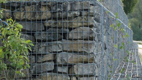 Produktbroschüre BauStatik - Geotechnik Titel der Produktbroschüre BauStatik - Geotechnik. Zu sehen ist eine Hangbefestigung aus Gabionen.